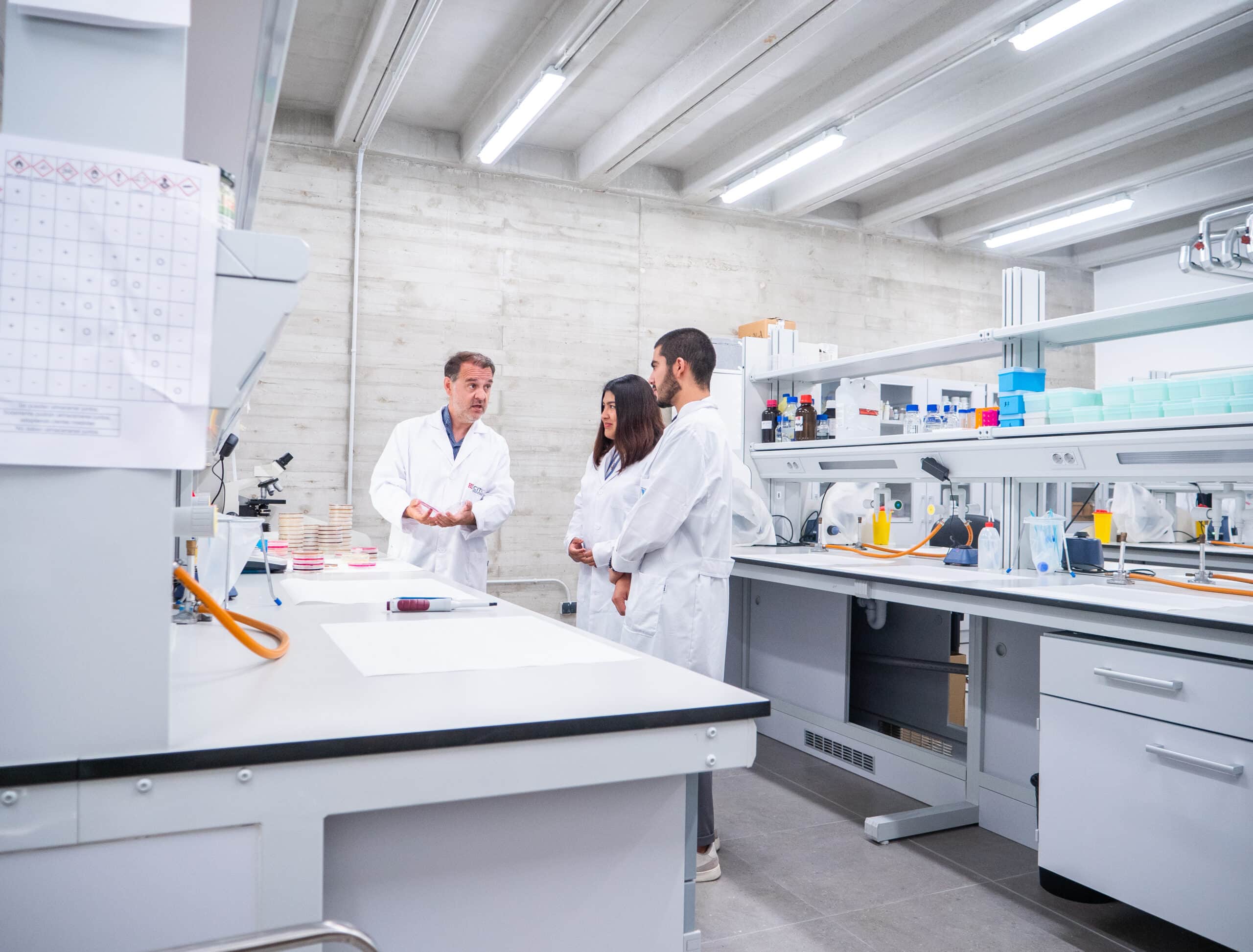 Laboratory researchers discussing scientific data in a modern research facility.
